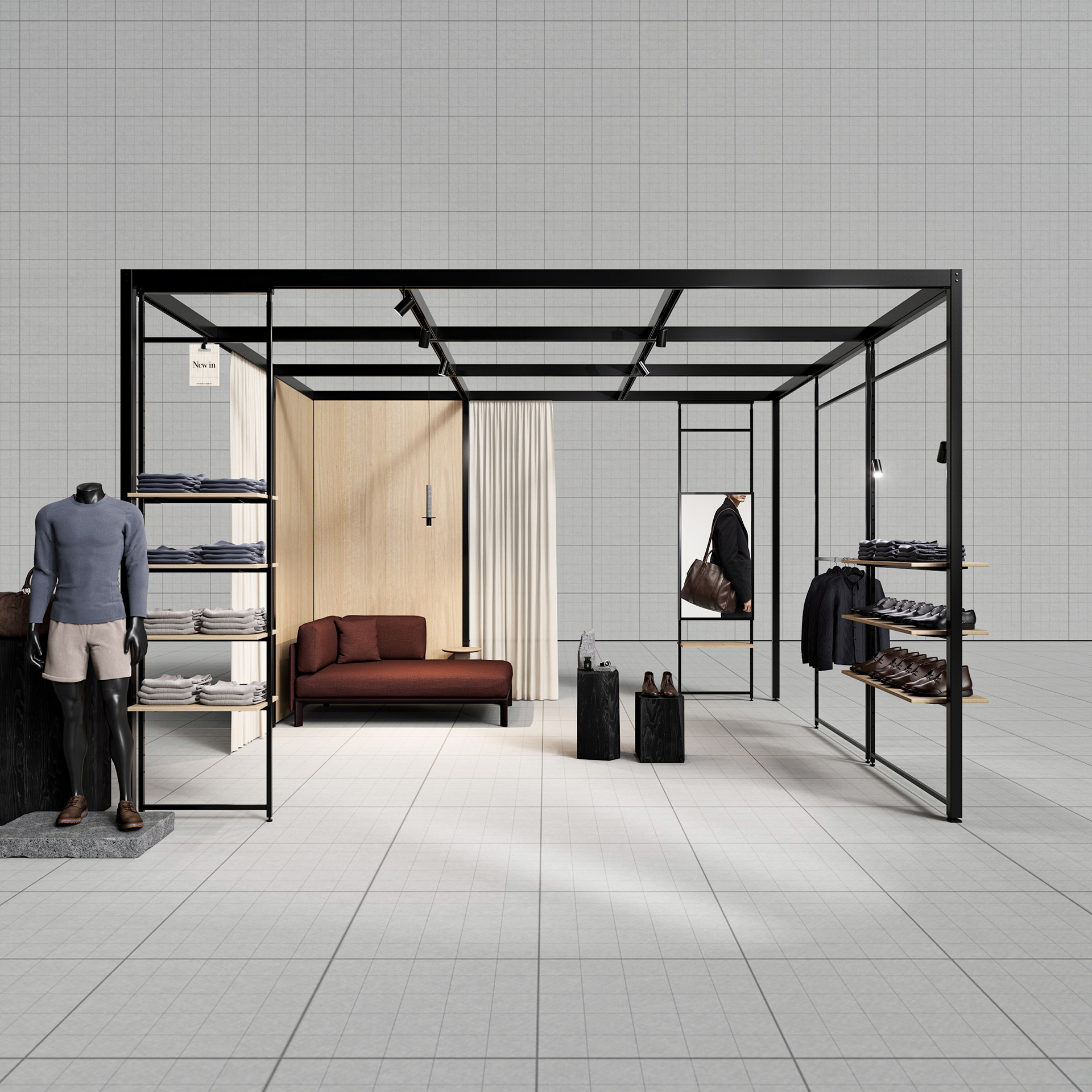 Freestanding black metal frame displaying men's clothing, shoes, two suitcases, and a brown sofa against a light wall with curtain.