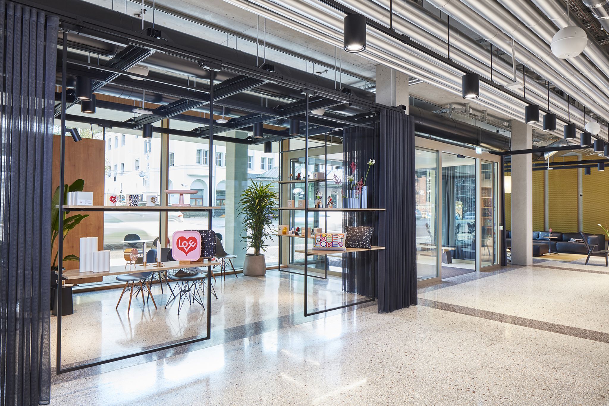 Large room divided by shelving elements and curtains.