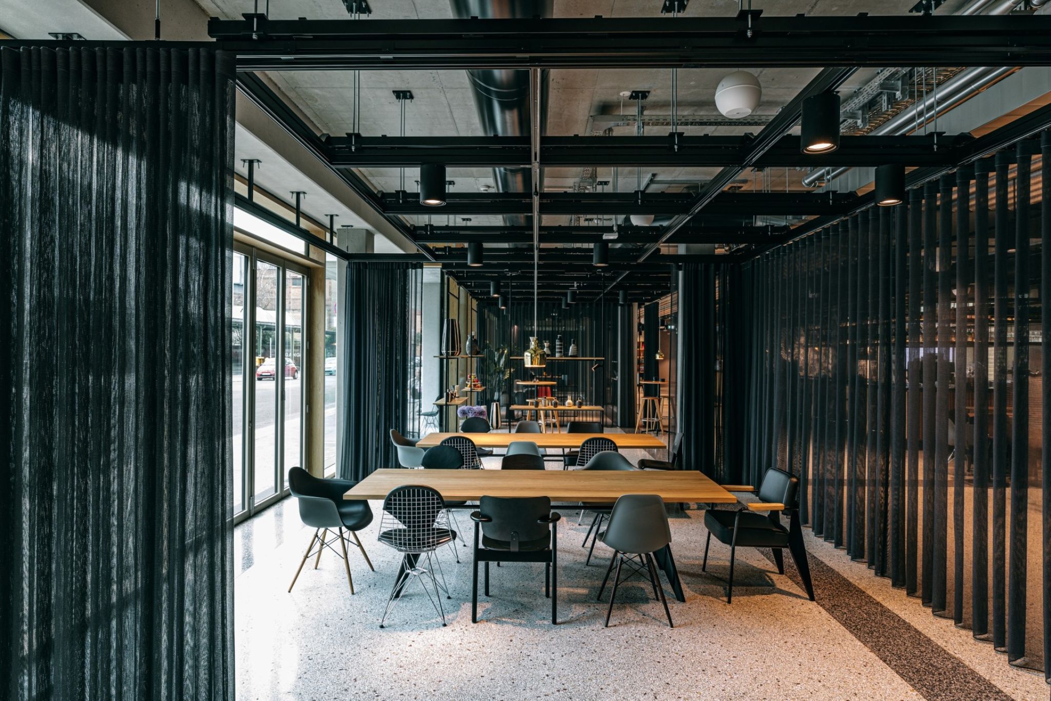 Modern room with a large table arrangement in the center and curtains to divide the space.