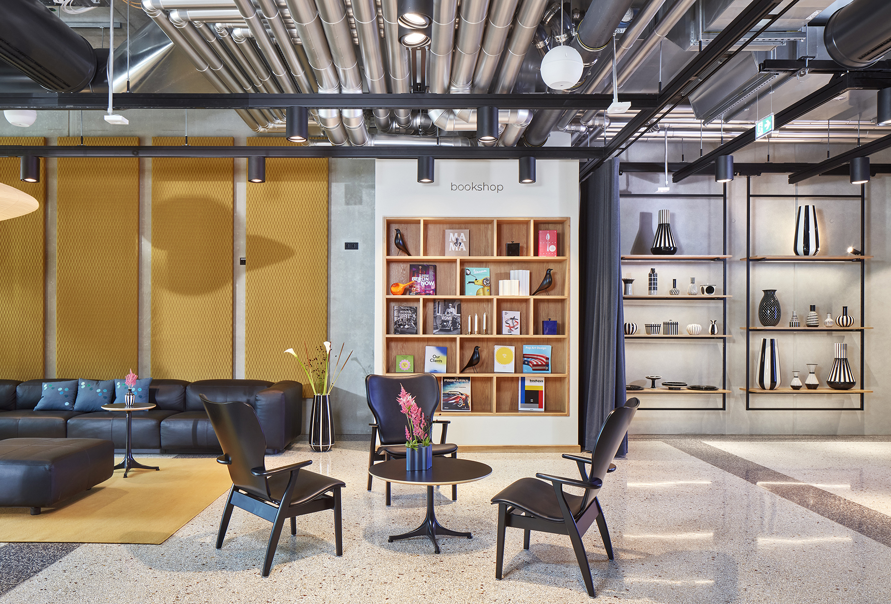 Lobby area of a hotel equipped with dark furniture and shelf elements.