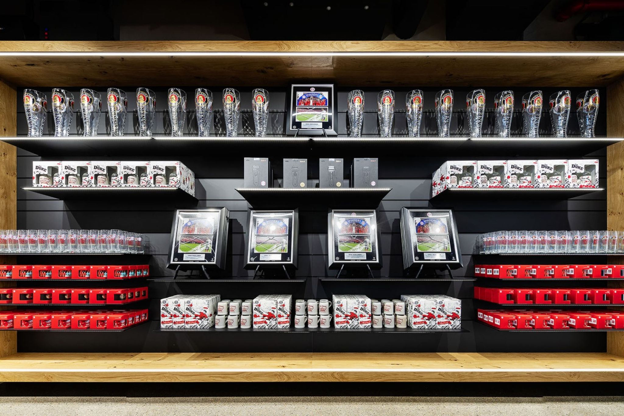Sales shelf with various merchandise products of FC Bayern Munich.