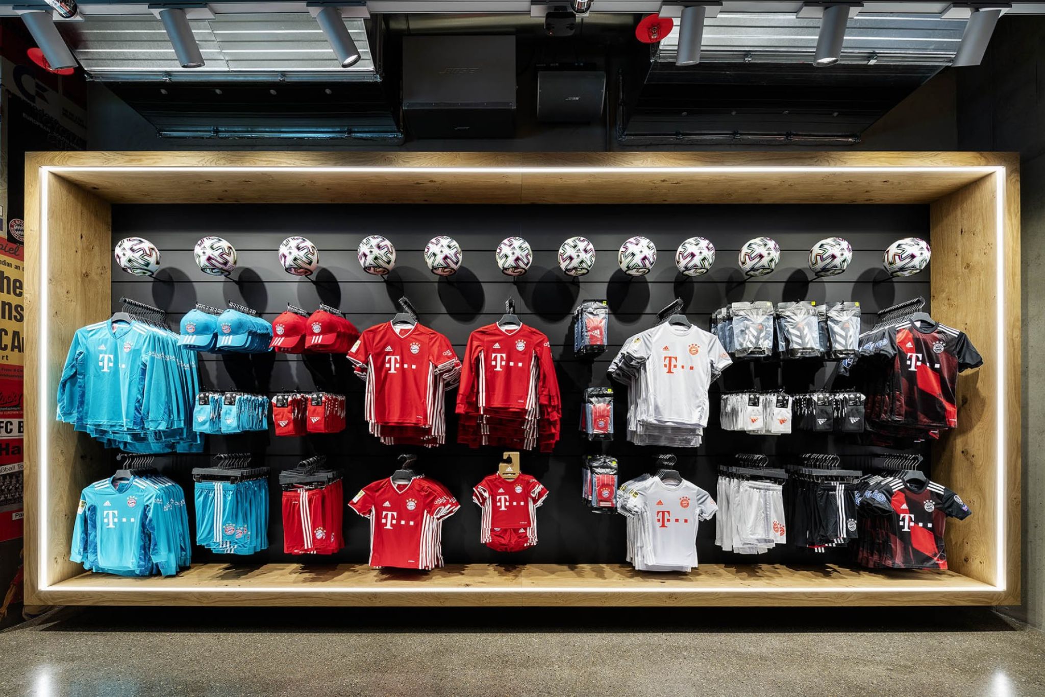 Fanshop sales shelf with jerseys and various merchandise items of FC Bayern Munich.