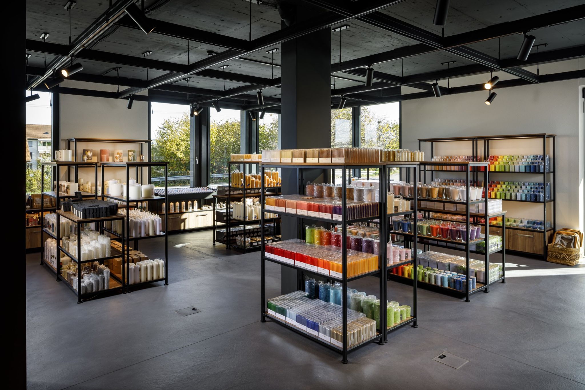Interior view of the HERZOG candle manufactory equipped with Visplay's shelving systems on which the candles are presented.