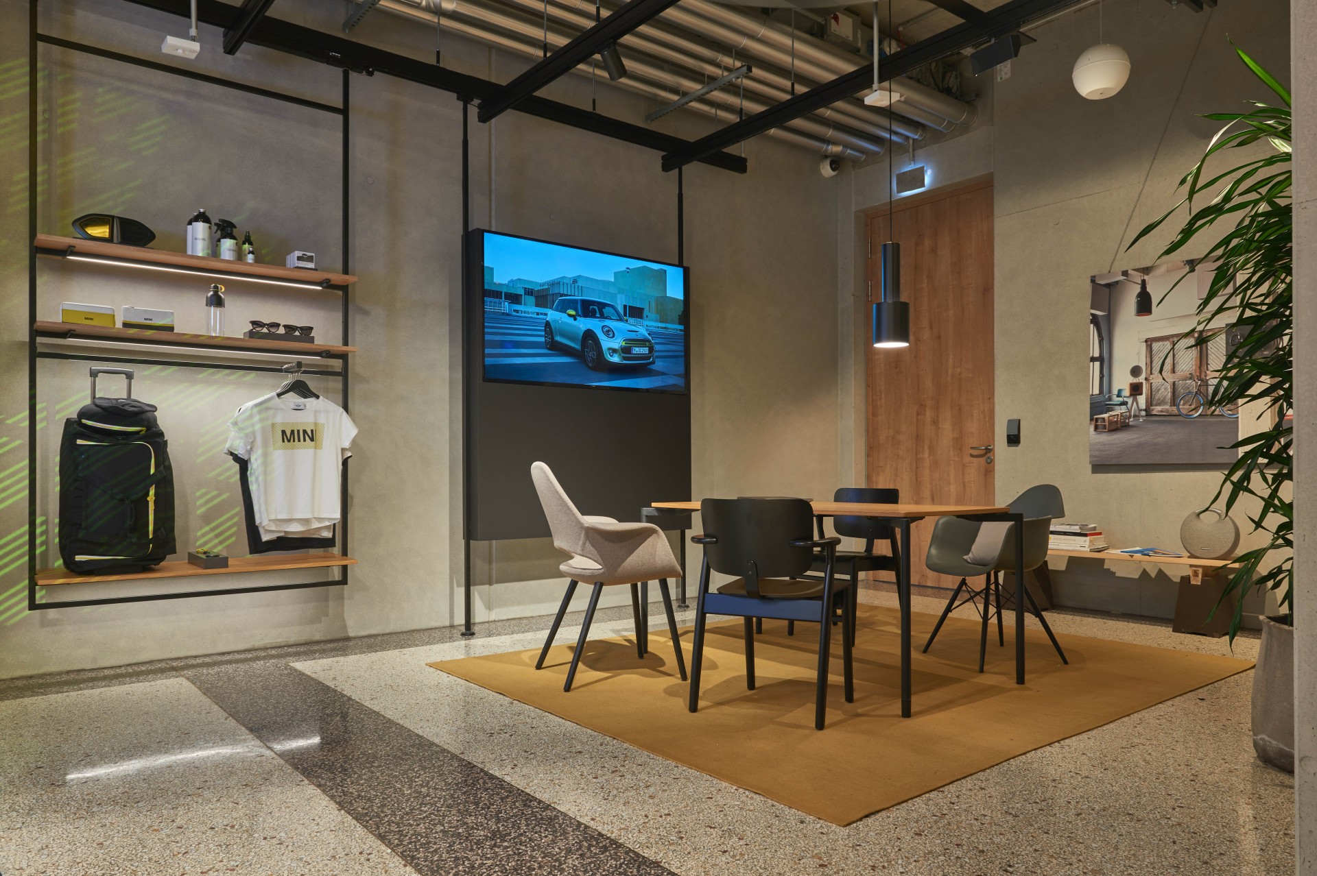 Room with a seating area and shelves equipped with merchandise items of the vehicle manufacturer MINI.