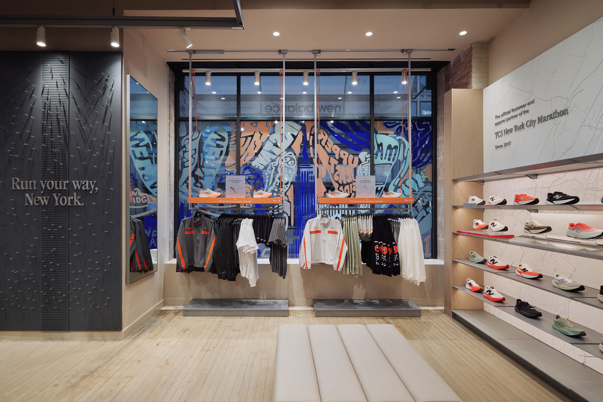 Interior of a sports store with running apparel, shoe shelves, and wall text 'Run your way, New York.'