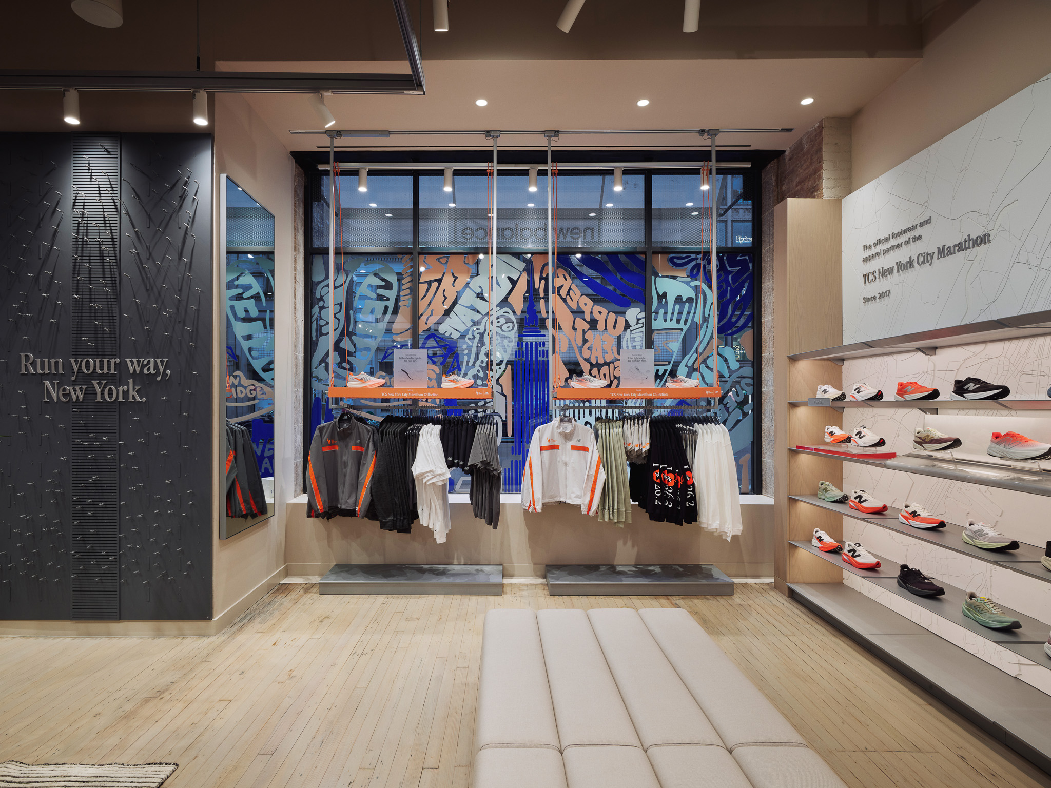 Interior of a sports store with running apparel, shoe shelves, and wall text 'Run your way, New York.'