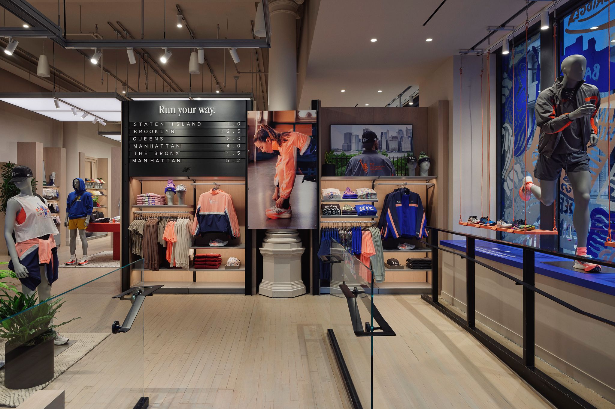 Interior of a store with sportswear, shelves holding folded sweaters, treadmills, and a mannequin dressed in athletic clothing.