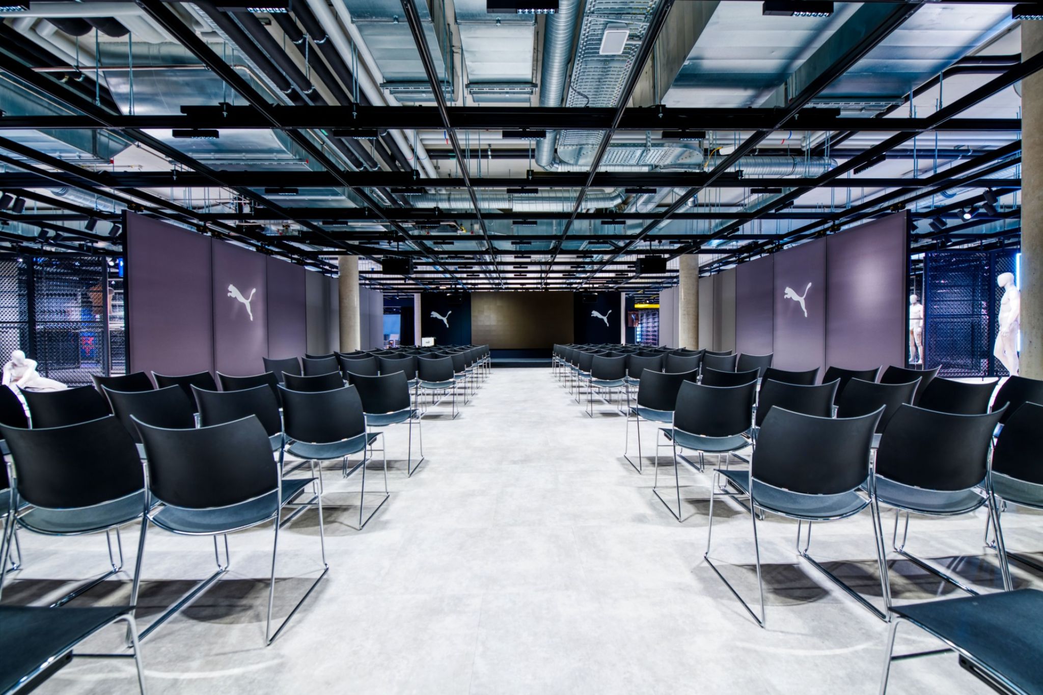 A large meeting room with partitions decorated with the logo of the Puma brand.