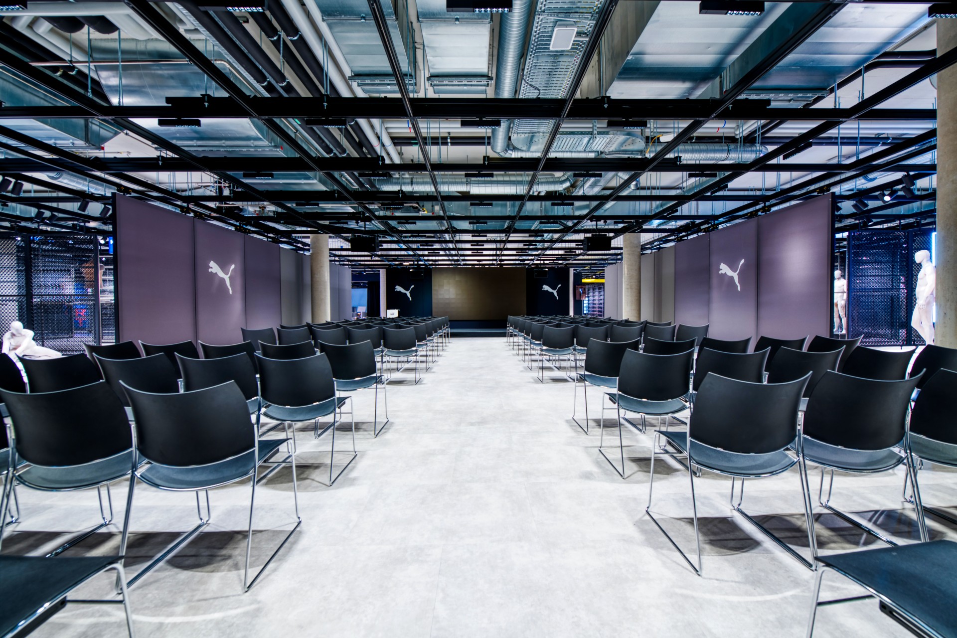 A large meeting room with partitions decorated with the logo of the Puma brand.