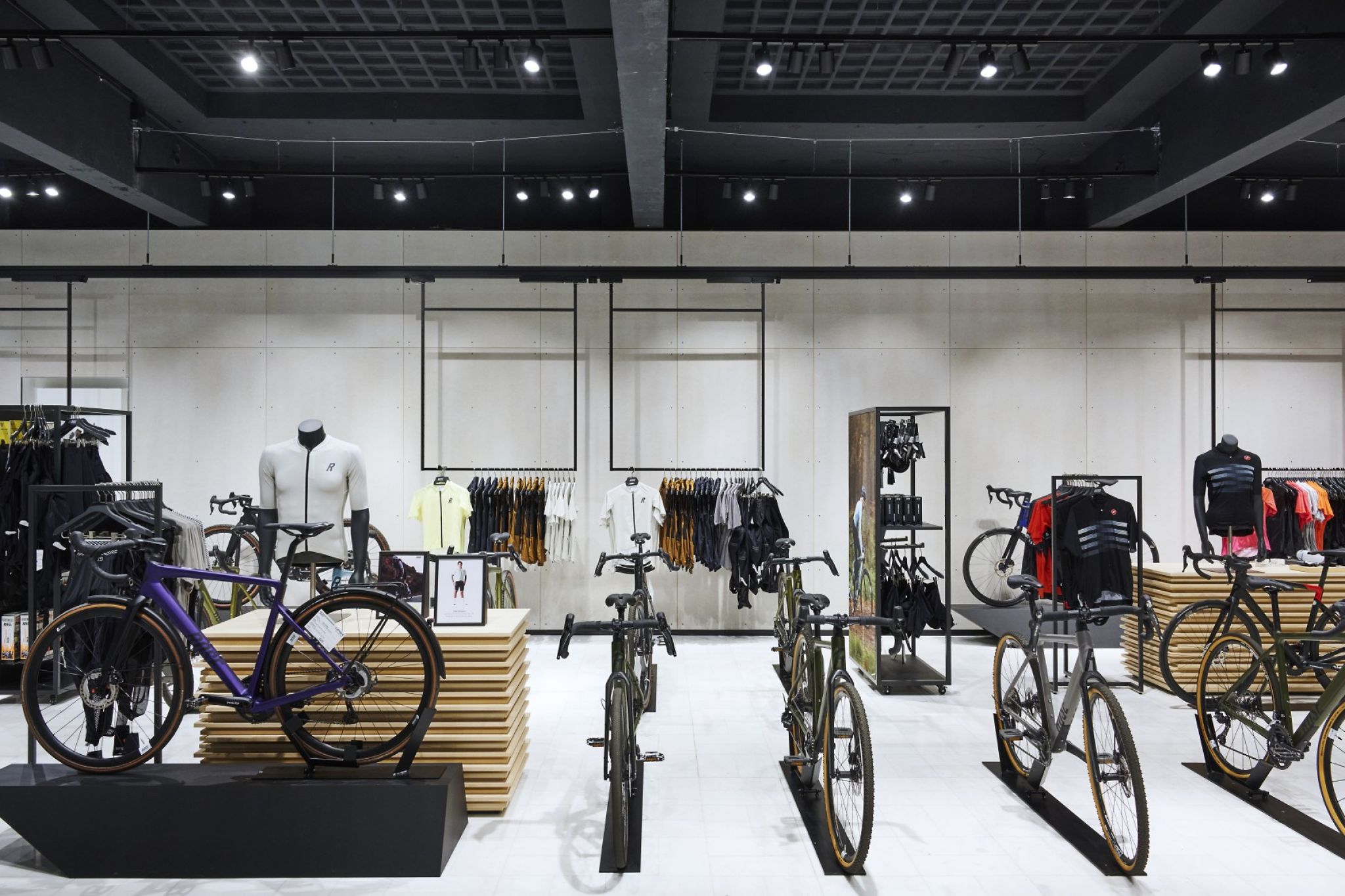 A bright bike store space with bicycles and merchandise racks including merchandise.