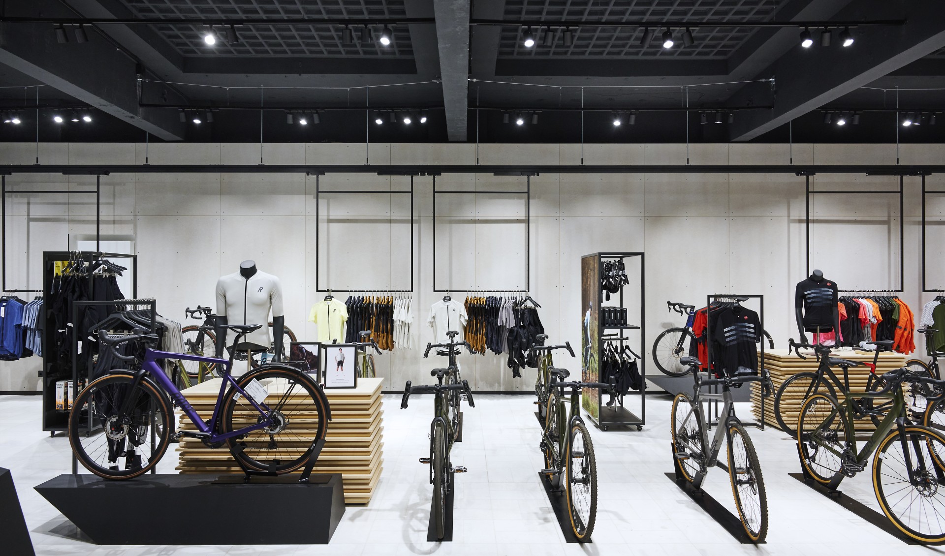A bright bike store space with bicycles and merchandise racks including merchandise.
