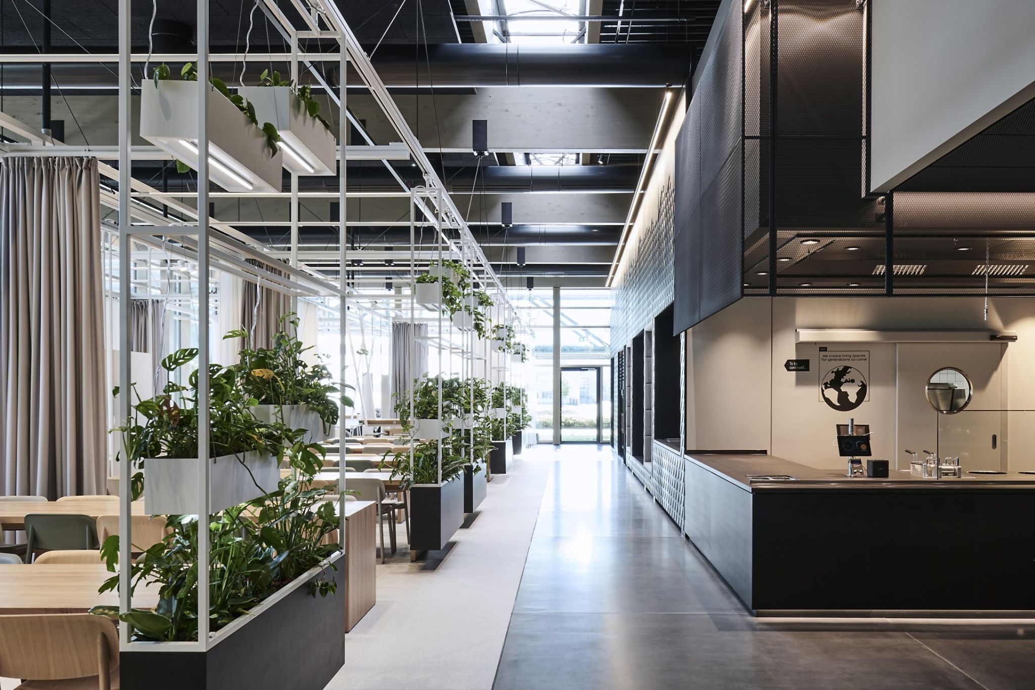Detail of a company canteen equipped with seating areas and plants.