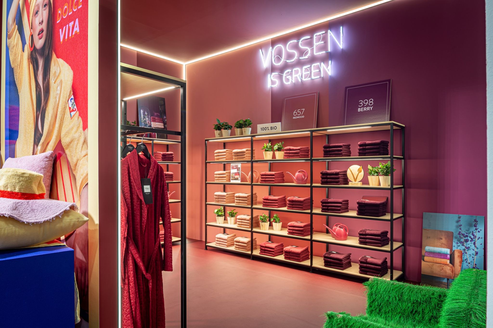 Commercial space with red walls and equipped shelves with bathroom textiles.