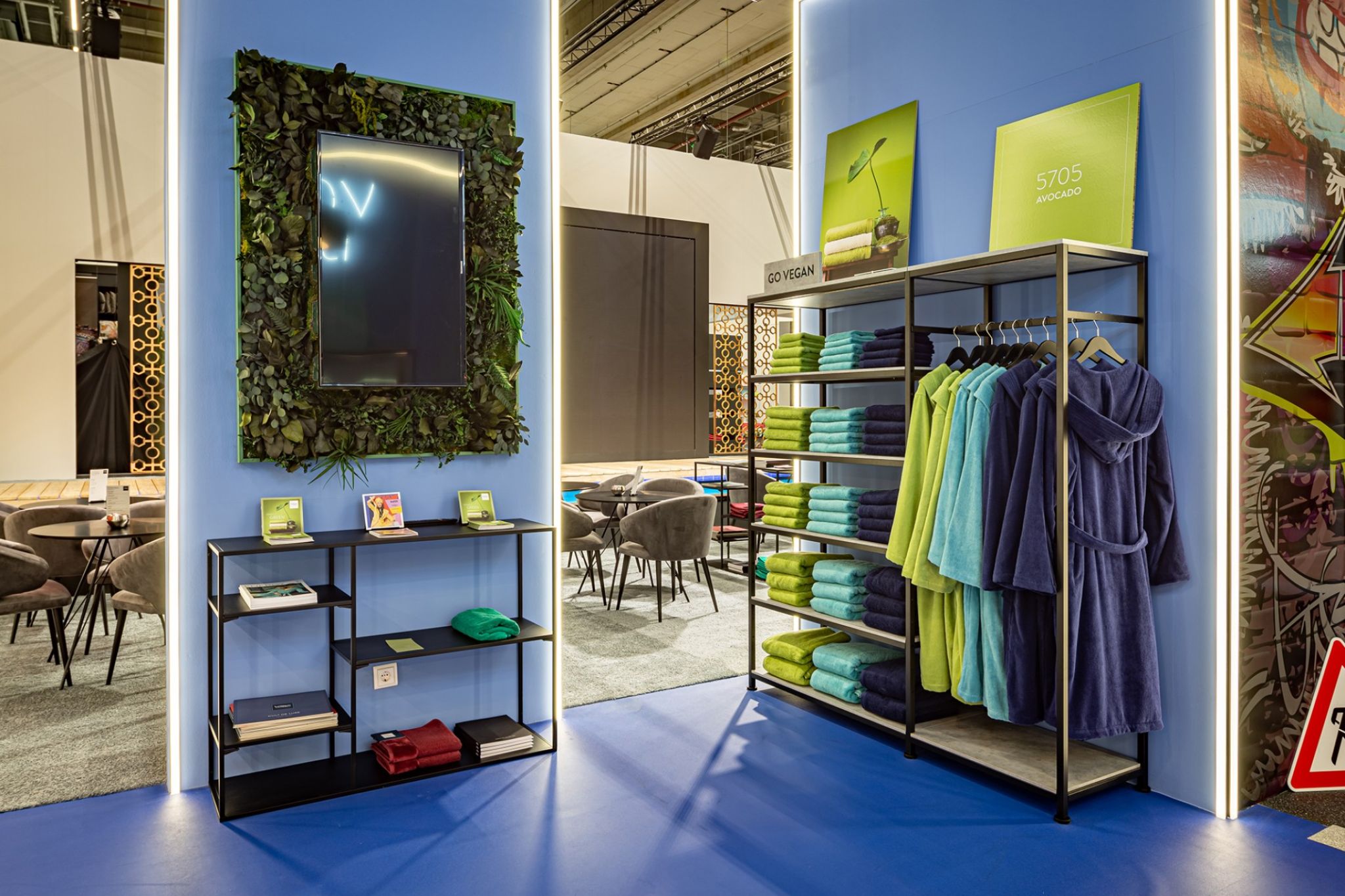 Decorated room with blue walls and bathroom textiles on merchandise carriers.
